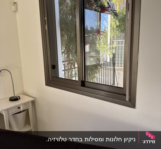 חלון פתוח עם נוף של עצים מבחוץ